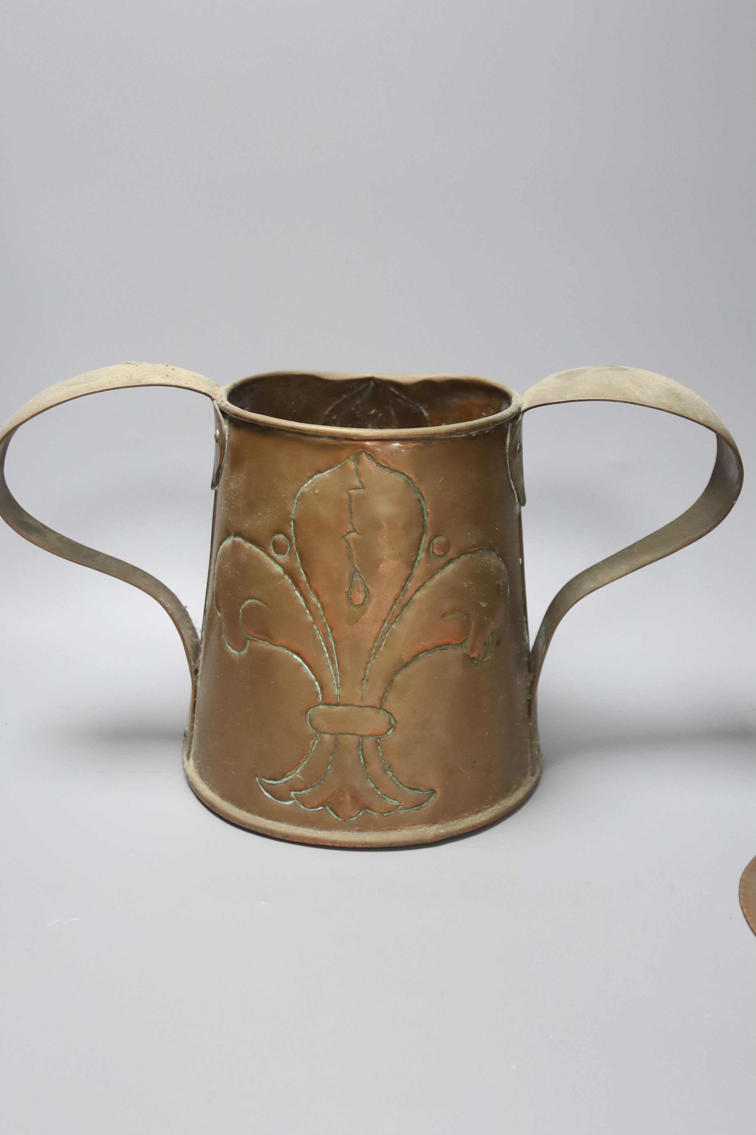 A Newlyn copper 'fish' bowl, together with a pair of Art Nouveau planished copper candlesticks and a similar two handled jug, largest 22cm